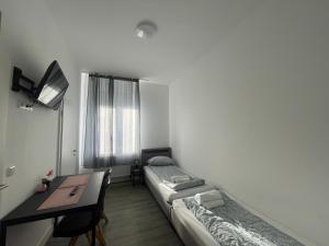 een kleine kamer met een bureau en een bed en een bureau sidx sidx sidx sidx bij Wesseling Htl. in Wesseling