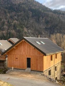 a barn with solar panels on the roof at La Tour de l'Enversin in Vaujany