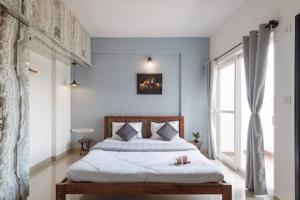 - une chambre avec un lit et une grande fenêtre dans l'établissement Blue Pearl Apartment by JadeCaps Nr Airport 3bhk, à Devanhalli