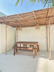 un tavolo da picnic in una stanza con soffitto in legno di Villa all day Pool Villa Hat Chao Samran หาดเจ้าสำราญ a Haad Chao Samran