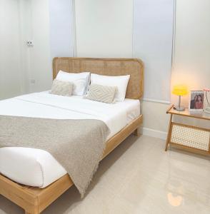 1 dormitorio con 1 cama y 1 mesa con lámpara en Villa all day Pool Villa Hat Chao Samran หาดเจ้าสำราญ, en Haad Chao Samran