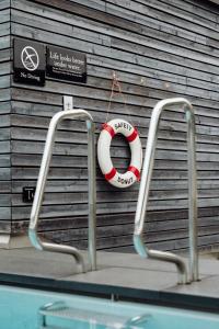 a life vest hanging on a wall next to a swimming pool at Roomers Baden-Baden, Autograph Collection in Baden-Baden