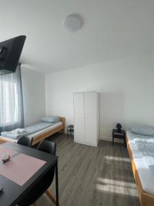 a room with two beds and a table in it at Wesseling Htl. in Wesseling