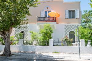 una casa con balcone e ombrellone arancione di Kosnian City Suites a Città di Kos