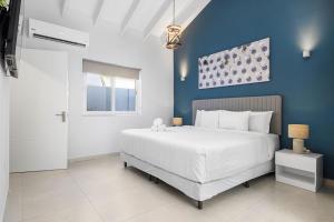 a bedroom with a white bed and a blue wall at New modern 3BDR/2BA Private Pool in Paradera
