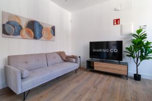 sala de estar con sofá y TV de pantalla plana en Simancas by SharingCo, en Madrid