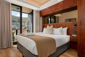 a bedroom with a large bed with a large window at Station House Apartments in Cape Town