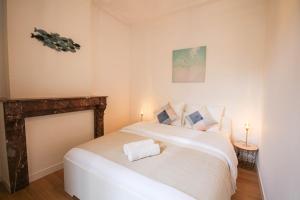 um quarto com uma cama branca e uma lareira em Fully-equipped apartment in city center + parking em Lille