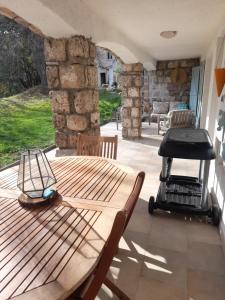 a patio with a wooden table and a grill at Peaceful Garden Apartment in Bargemon +12 photos