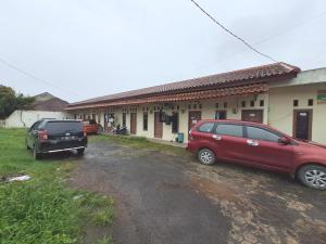 two cars parked in front of a building at OYO 93590 Penginapan Palapa 10 Syariah in Bandar Lampung