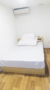 a white bed in a room with a wooden floor at Hananogo Ikebukuro - Vacation STAY 16064v in Tokyo
