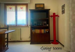 a living room with a red cross and a tv at La casa di Agilla in Tuoro sul Trasimeno