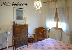 a bedroom with a bed and a dresser and a window at La casa di Agilla in Tuoro sul Trasimeno