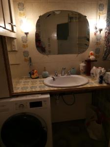 lavabo con espejo y lavadora en Villa Meurice, en Étrembières