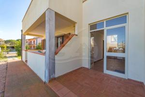 eine Außenansicht eines Hauses mit Glasschiebetür in der Unterkunft Appartamenti Rosa Campo Mare - Goelba in Marina di Campo