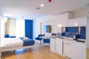 a bedroom with a bed and a kitchen with a table at ORBI CiTY-sea view aparthotel in Batumi