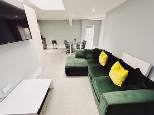 sala de estar con sofá verde y almohadas amarillas en 2 Bedroom Apartment in the Heart of Newcastle - Modern - Sleeps 4, en Newcastle