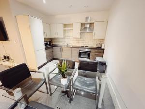 a living room with a glass table and chairs at 2 Bedroom Apartment in the Heart of Newcastle - Modern - Sleeps 4 in Newcastle upon Tyne