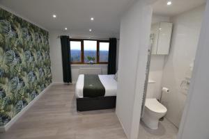 a small bedroom with a bed and a toilet at The Hive 4 Bed House Pool Table Air-con in Maidstone