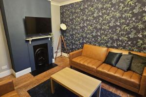 a living room with a couch and a fireplace at The Hive 4 Bed House Pool Table Air-con in Maidstone