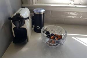 a counter top with a bowl of rocks and a container ofocolapses at The Indooroopilly Queenslander - 4 Bedroom Family Home - Private Pool - Wifi - Netflix in Brisbane