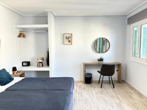 a bedroom with a bed and a desk and a mirror at Nelly's Luxury Suites in Kassiopi