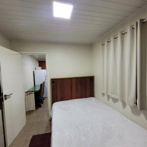 een kleine slaapkamer met een bed in een kamer bij Kitnet em Torres 2 pessoas in Torres