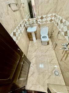 a bathroom with a toilet and a sink at Al Atif Hotel in Islamabad