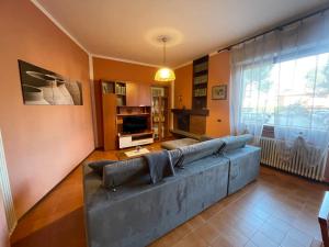 uma sala de estar com um sofá e uma televisão em Casa Variante em Cannobio