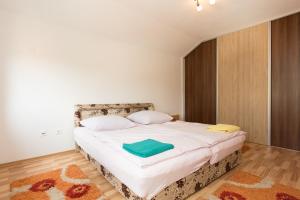 ein Schlafzimmer mit einem großen Bett mit weißer Bettwäsche und Kissen in der Unterkunft EM Apartment in Sarajevo