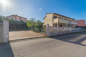 ein Haus mit einem Zaun vor einer Straße in der Unterkunft Appartamenti Rosa Campo Mare - Goelba in Marina di Campo