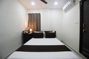 a bedroom with a large bed with a window at Hotel Stayo Gachibowli in Hyderabad