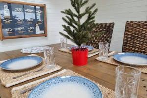 a table with blue plates and a christmas tree on it at Waterfront Scotland Island Holiday Home - Family & Pet Friendly - 3 Bedrooms - Wifi - Netflix - Private Jetty in Scotland Island