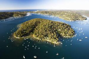 une île dans l'océan avec des bateaux dans l'eau dans l'établissement Waterfront Scotland Island Holiday Home - Family & Pet Friendly - 3 Bedrooms - Wifi - Netflix - Private Jetty, à Scotland Island
