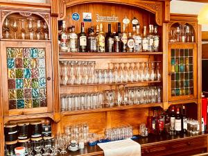 a bar with glasses and bottles of alcohol at Hotel zur Post in Schalksmühle