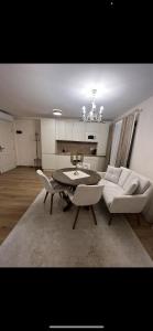 - un salon avec un canapé, une table et des chaises dans l'établissement Apartament HERA, à Alba Iulia