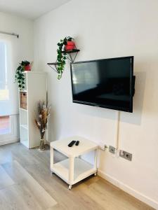 sala de estar con TV de pantalla plana en la pared en Apartamento con vistas al mar y plaza aparcamiento, en Chilches