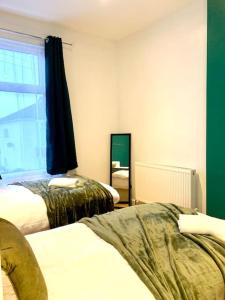 Elegant 3 bed flat with Parking في بورتسماوث: غرفة فندقية بسريرين ونافذة