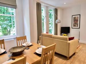 uma sala de estar com uma mesa e um sofá em Your Space Apartments - Jubilee House em Cambridge