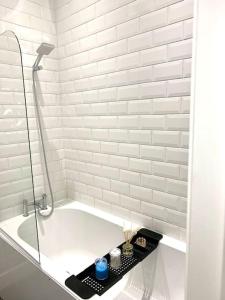 a white bath tub with a black tray in a bathroom at Elegant 3 bed flat with Parking in Portsmouth