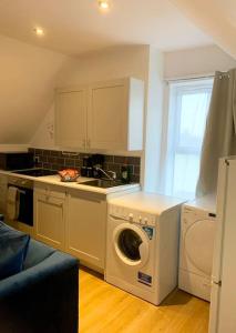 Elegant 3 bed flat with Parking في بورتسماوث: مطبخ مع غسالة ومغسلة