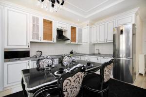 La cuisine est équipée d'une table et d'un réfrigérateur en acier inoxydable. dans l'établissement Двухкомнатные апартаменты ЖК Шахристан 213, à Almaty