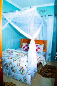 a bedroom with a bed with a canopy at Stay in Bomang'ombe with Breakfast in Moshi