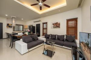 sala de estar con sofá y ventilador de techo en Villa Kaheru | 3 bedroom priavate pool villa | Kokyang Estate, en Nai Harn Beach