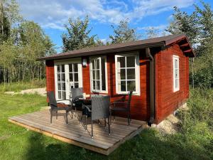 a small cabin with a table and chairs on a deck at Salu summer cottage in Vadi