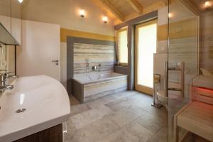 un bagno con vasca, lavandino e vasca da bagno di Haus Sternenblick a Drachselsried Altre 14 foto