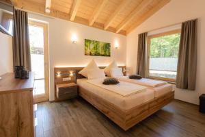 a bedroom with a large bed and a large window at Haus Sternenblick in Drachselsried