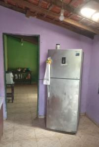 un frigorifero in una stanza con una parete viola di Aloha LC Hostel a Luis Correia