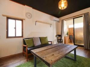 uma sala de estar com um sofá e uma mesa em (旧信濃Natural)新規オープン！深呼吸したくなるゲストハウス。長野駅前徒歩8分！ em Nagano