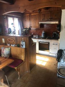 uma cozinha com armários de madeira e um forno com placa de fogão em Chalet Mex em Saint-Maurice